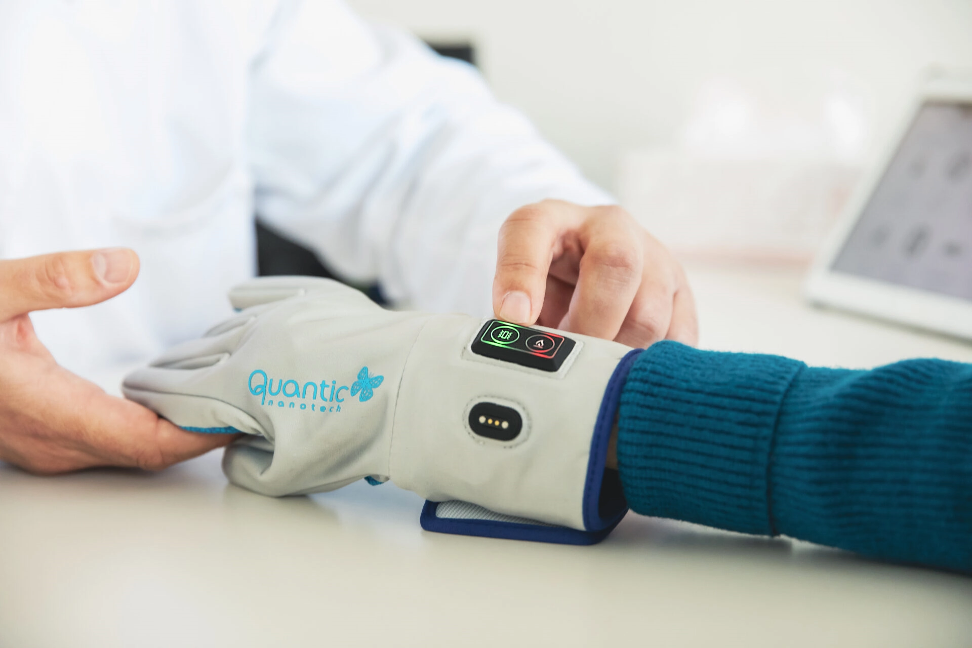 Profesional sanitario ajustando el guante electrónico Quantic en la mano de una paciente